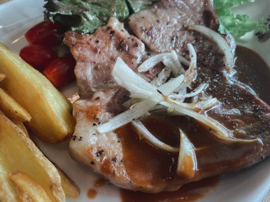 Grilled black pepper pork steak with french fries. Closed up picture
