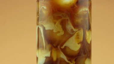 Sütlü kremayla karıştırılmış kahve. Süt yavaş çekimde kahveye dökülüyor.