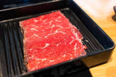 Çiğ et. Siyah tepside taze et dilimi. Yakiniku ya da ızgara et için çok az pişmiş et..