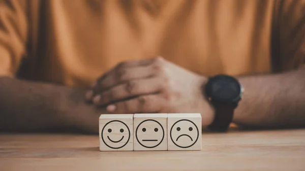 Feedback rating concept. Customer service experience feedback emotion and satisfaction survey. Wooden cube with smiley, normal and sad face icon. Service rating and customer satisfaction concept