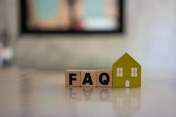Wooden blocks with the word FAQ for home, frequently asked questions. Collection of frequently asked questions on any topic and answers to them about home. Instructions and rules on Internet sites