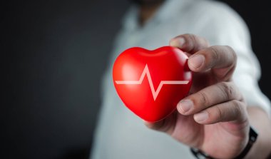 Kırmızı kalbi beyaz kardiyogram sinyaliyle tutan adam. Sağlık, hayat sigortası iş konsepti, dünya kalp günü, dünya sağlık günü