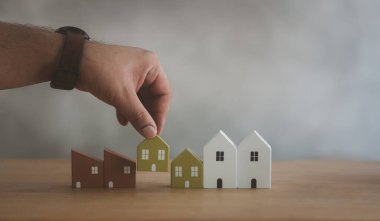 Tahta masadaki modelden seçilmiş küçük ahşap ev modeli, gayrimenkul planlaması. En iyi ev kredisi konsept yapısını seçin.