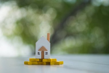 Sarı bir yıldıza yerleştirilmiş ahşap ev modeli. En iyi ev ve teklif evi. Gayrimenkul yönetimi konsepti, puan verme konsepti.