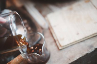 Profesyonel baristanın eli bardağa yeni demlenmiş damlatılmış kahve dolduruyor. Kahve hazırlıyorum..