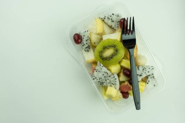 Plastik kutuda siyah çatallı meyve salatası. Üst görünüm