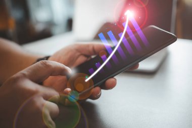 Adam akıllı telefondan sanal ekrana dokunarak finansal yatırım ve teknoloji geliştirme ile başarı ve büyüyen büyüme grafiğini sanal ekranda analiz ediyor.