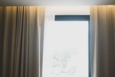 Basit oda içinde kahverengi perdeleri olan bir pencere. Kapat.