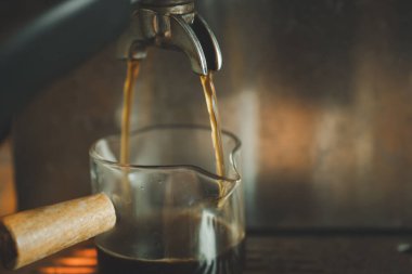 Espresso makinesinde cam kahve fincanlarını hazırlamaya başlayın. Kahve makinesi kahve yapıyor.