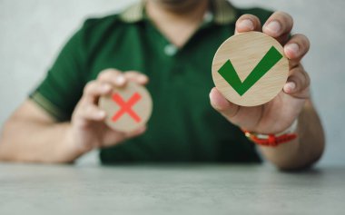 Tahta bloklar doğru işaretleri gösteriyor ve elle yapılan işler, kararlar ve düşünceler yanlış. Onaylama teması. Tercih hakkı tahta bloklarda evet.