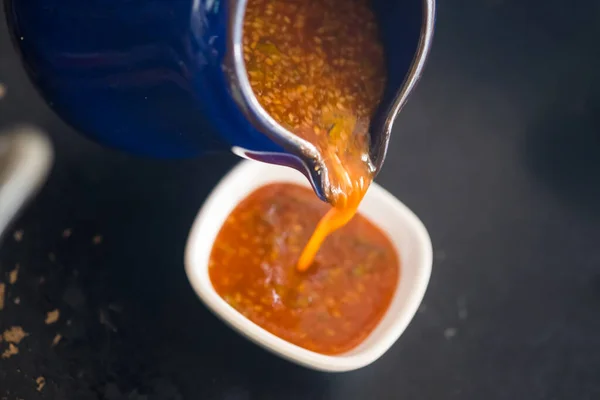 stock image Pour suki sauce in to white bowl. Thai Suki Sauce. Close up