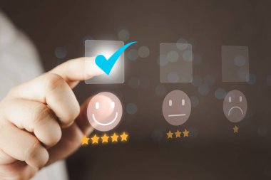 Adam mutlu yüz ikonundaki sanal ekrana dokunuyor ve hizmette tatmin olmak için beş yıldız alıyor. Düşünce oranı çok etkileyiciydi. Değerlendirme müşteri hizmetleri ve geri bildirim kavramı.