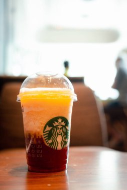 Bangkok, Tayland 29 Temmuz 2023 Starbucks 'ta bir bardak Starbucks içkisini ahşap masaya koy.