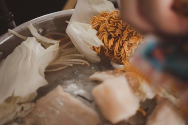 Tavadaki hazır erişteleri yakın çekim. Sıcak tavada Mookata Meat geleneksel Tayland usulü barbekü, karides ve sebzeli domuz eti tavası ve domuz çorbası. Izgara et, yağlı yemek.