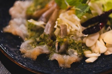 Balık soslu karidesi bir tabak sarımsakla servis et..