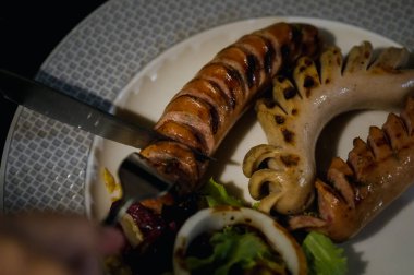 Izgara sosis yerken çatal ve bıçak kullanan tanınmaz bir adam. İştah açıcı bira aperatifleri. Bar konsepti
