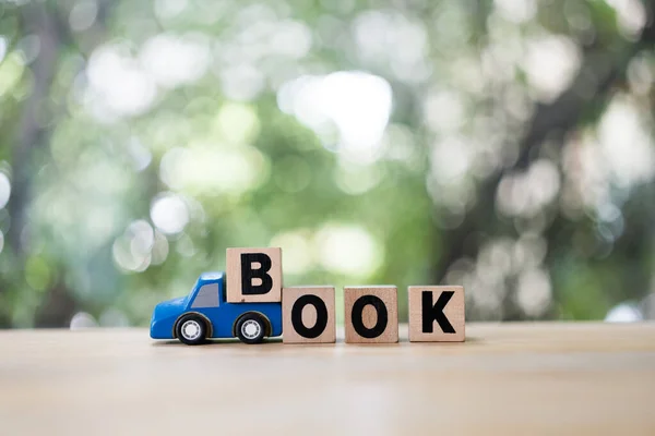 Blue toy car with wood block of text book rental car. Online booking concept. Travel concept