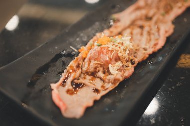 Bir tabak dilimlenmiş ve kavrulmuş Japon bifteği suşisi.