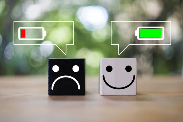 快乐和愤怒的脸在木块上与电池图标在消息图标 消极和积极的情感概念 情绪的概念 快乐的工作环境 — 图库照片
