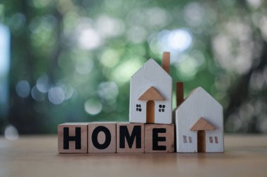 Tahta bloklar ev ve iki küçük ev modelini doğal arka plana itiyor. Emlak yatırımı ve emlak kavramı, çevre dostu bina.