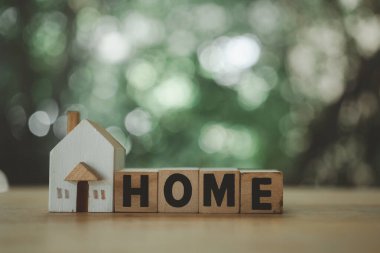 Ahşap bloklar ev ve küçük ev modelini doğaya karşı ifade ediyor. Gayrimenkul yatırım güven kavramı.