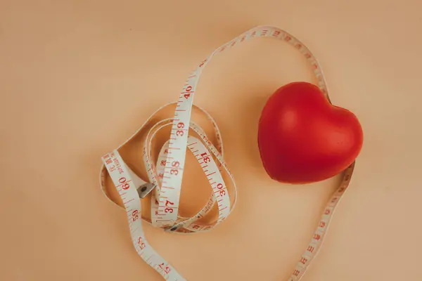 Top view red heart shape and white measurement tape. Heart check up or checking size concept