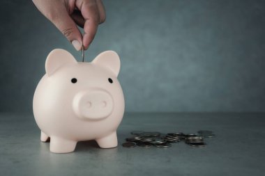 Biriktirmek ya da yatırım yapmak için kumbaranın içine bozuk para koyan adama yaklaş. Para tasarrufu kavramları