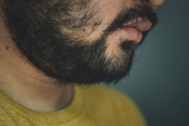 Yüzünde sakal çıkan Asyalı bir adam yüzü. Sakal, insanın çenesinde, üst dudağında, yanaklarında ve boynunda büyüyen kılların toplamıdır..