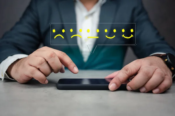 Customer experiences concept. Face icon for giving feedback via phone app, from negative to positive review. Man rating his experience using an app on a cell phone.