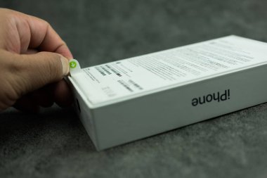 Bangkok, Tayland - 12 Ekim 2023: Yeni iPhone 15 profosyonel titanyum beyaz paketi açan bir adam, içinde Apple tarafından tasarlanmış 15 Pro modeli içeren akıllı telefon
