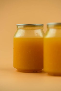 Turuncu arka planda plastik organik meyve suyu şişeleri..