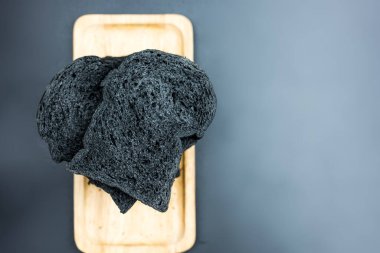 Ahşap tepside siyah kömür ekmeği dilimle. Üst görünüm