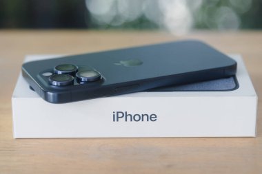Bangkok, Tayland - 27 Ekim 2023: Yeni iPhone 15 Pro Titanyum Blue 'nun arka görüntüsü, bir kutuda yüzüstü yatıyor. Teknolojik akıllı telefon modern tasarımı.