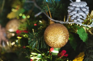 Noel ağacına asılı altın ve parıltılı bir balo