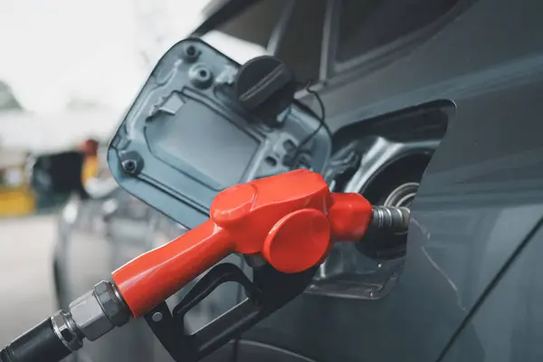 Car fueling at gas station. Petrol pump filling fuel nozzle in fuel tank of car at gas station. Petrol industry and service. Petrol price and oil crisis concept.