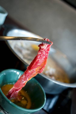 Çiğ yumurtaya çiğ sığır etli maşa, shabu shabu Japon yemeği stili.