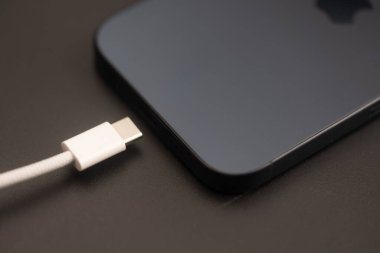 Bangkok, Tayland - 11 Kasım 2023: Usb tip C kablo şarj edici iPhone 15 Pro blue Titanium siyah arka planda