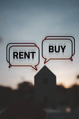 Elle tutulan ahşap evde günbatımına karşı Alış ya da Kirala mesajı var. Emlak konsepti, karar verme