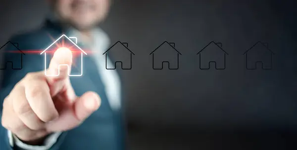 İş adamı en iyi evi seçmek için sanal ekranda ev simgesini seçin. Satın almak için çeşitli çevrimiçi pazarlama sistemleri ve teknoloji platformları kavramı.