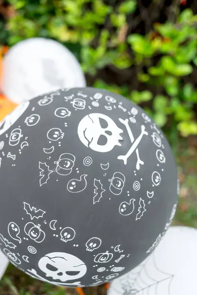 Halloween black balloons decorated in garden. Halloween party activity ideas
