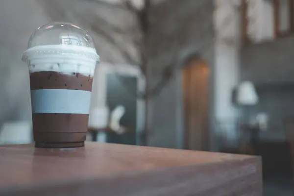 Mocha coffee cold in to go plastic glass with the lid at cafe