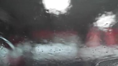 Otomobilin içinden bak. Köpük ve su, temiz su spreyiyle yıkanan arabaya damlıyor. Profesyonel bir oto yıkama istasyonunda sabun köpüğü sıkmak ve araba yıkamak..