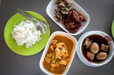 Tayland yemekleri, domuz eti, körili yumurta, ahşap masada pilav yemek gibi. Üst görünüm