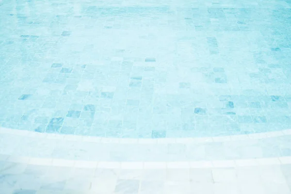 Clear blue water in the pool, curved swimming pool. Step into the water and finish the pool bottom slab mosaic