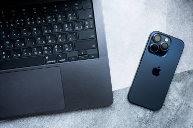 Bangkok, Tayland - 5 Aralık 2023: Modern akıllı telefon Apple New iPhone 15 profesyonel maksimum mavi titanyum ve Apple MacBook Pro M3 Max uzay siyah dizüstü bilgisayar. 2023 'te Apple' dan yeni ürünler