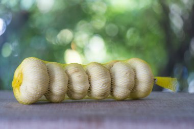 Sarı çantada bir demet taze Tayland sarımsağı.