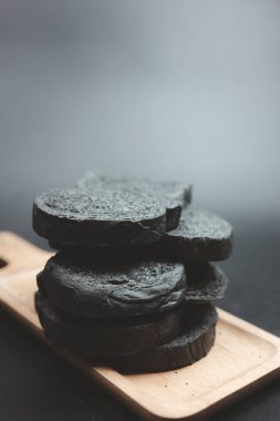 Ahşap tepside servis edilen bir dilim kömür ekmeği.