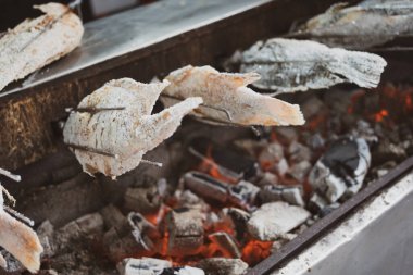 Tuzlu ızgarayla kaplanmış balık. Şöminede otomatik dönme makinesiyle ızgara balık. Tayland 'da sokak yemeği