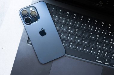 Bangkok, Tayland - 12 Aralık 2023: iPhone 15 profesyonel mavi titanyum MacBook Pro, M3 Max 2023, Space Black renk