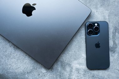 Bangkok, Tayland - 12 Aralık 2023: Modern akıllı telefon Apple New iPhone 15 pro blue titanium ve Apple MacBook Pro M3 Max space black laptop. 2023 'te Apple' dan yeni ürünler